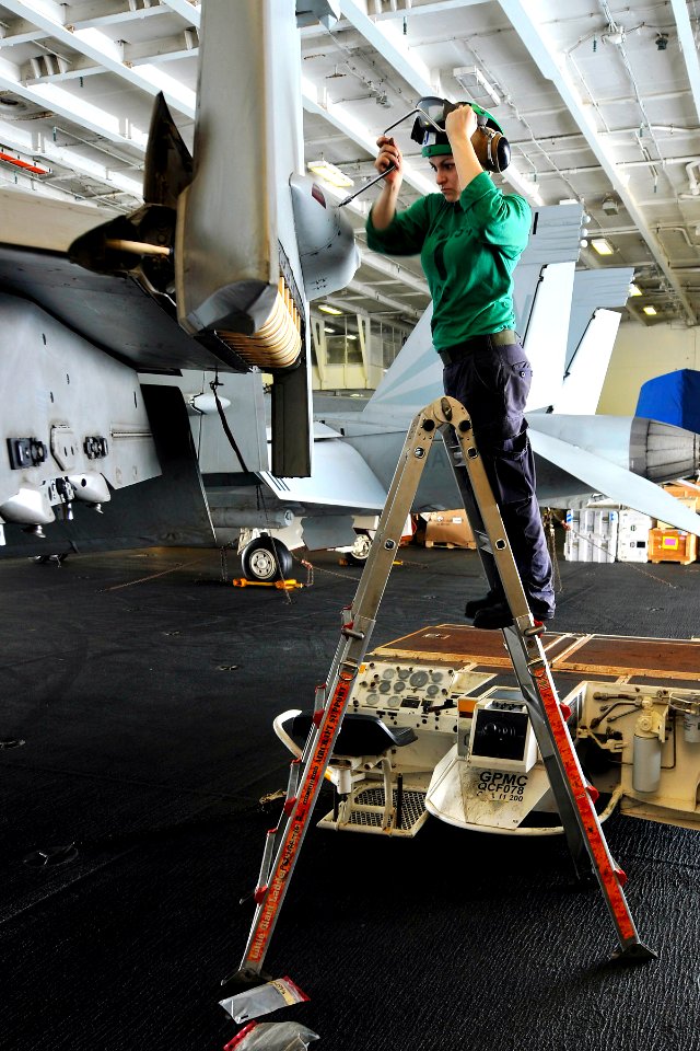 US Navy 110625-N-EE987-045 Aviation Machinist's Mate Airman Journey Domingo, from Manteca, Calif., installs a 159 Canoe panel onto an F-A-18 Super