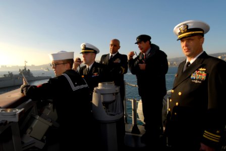 US Navy 110624-N-ZI300-043 Cmdr. Roy Love, commanding officer of the guided-missile frigate USS Boone (FFG 28), middle, relays commands while arriv