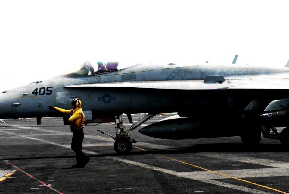 US Navy 110627-N-GL340-081 An Aviation Boatswain's Mate (Handling) guides an F-A-18C Hornet aboard USS Ronald Reagan (CVN 76)