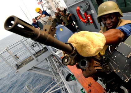 US Navy 110624-N-YM590-125 Electronics Technician 2nd Class Timothy Carter changes the barrel of an M240B machine gun during weapons training aboar