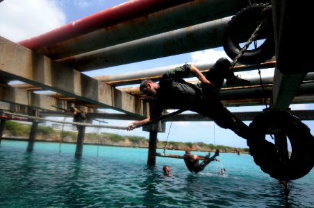 US Navy 110627-N-YO394-553 Operations Specialist 2nd Class Joshua Mederos, right, assigned to Riverine Squadron (RIVRON) 3, climbs across a rope li