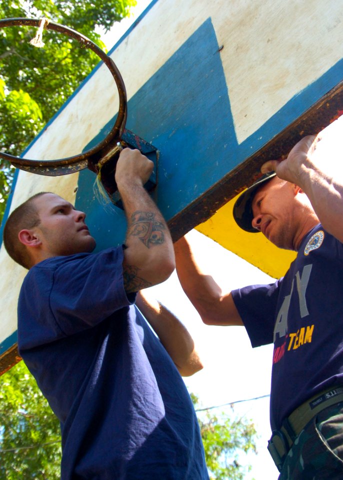 US Navy 110629-N-VY256-066 A U.S. Navy and an Armed Forces of the Philippines Navy sailor replace a basketball goal during a community service proj