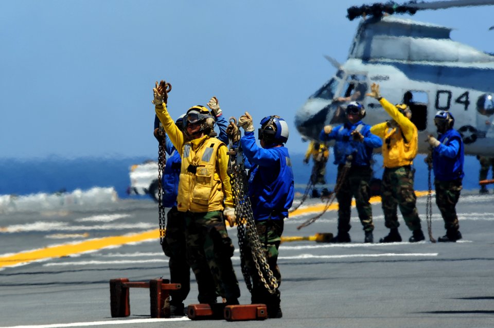 US Navy 110629-N-WA347-314 Aviation boatswain's mates show their chocks and chains to Marine helicopter pilots during flight operations aboard the