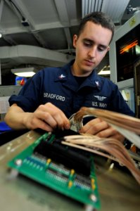 US Navy 110626-N-CH661-014 Aviation Electronics Technician 3rd Class Anthony C. Bradford troubleshoots a cass interface device aboard USS Enterpris