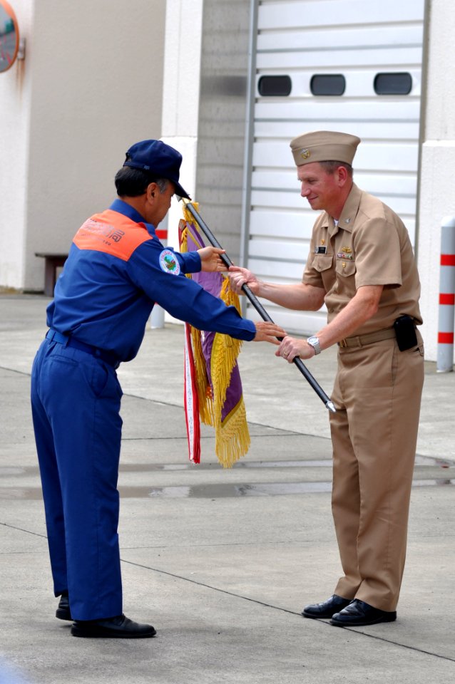 US Navy 110628-N-SF508-035 A member of the Yokosuka City Fire Bureau returns the Red Rooster flag to Capt. David Owen before the 62nd annual Red Ro