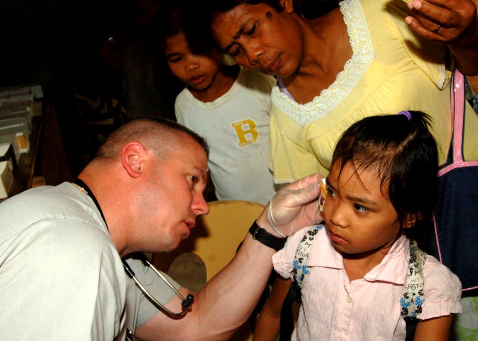 US Navy 110629-N-NJ145-150 Senior Chief Hospital Corpsman Tom Gilham treats a patient during a medical community service project during Cooperation