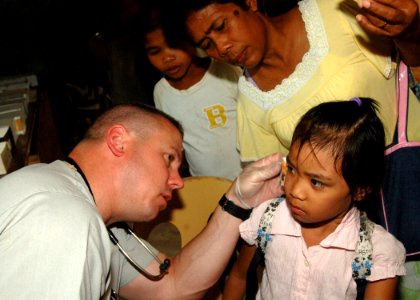 US Navy 110629-N-NJ145-150 Senior Chief Hospital Corpsman Tom Gilham treats a patient during a medical community service project during Cooperation
