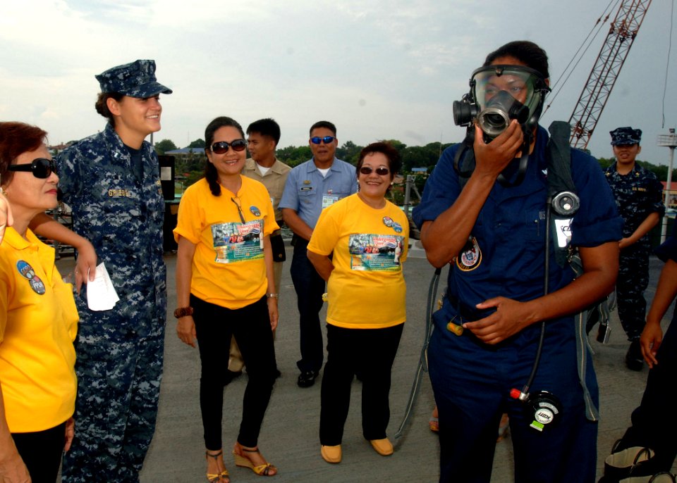 US Navy 110630-N-NJ145-111 Damage Controlman 3rd Class Yahaila Hernandez demonstrates a self-contained breathing apparatus to Philippine Navy sailo