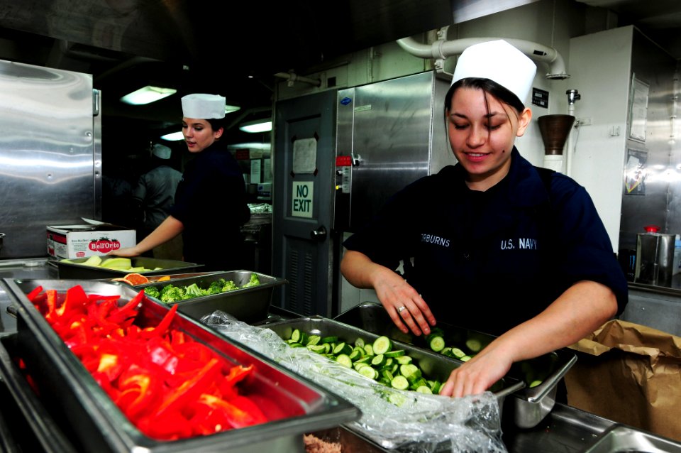 US Navy 110628-N-SB672-002 Culinary Specialist Seaman Meagan Taylorburns, from Bakersfield, Calif., prepares cucumbers in the aft galley of the air