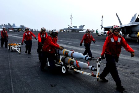 US Navy 110629-N-EE987-227 Aviation Ordnancemen assigned to the Argonauts of Strike Fighter Squadron (VFA) 147 transport ordnance across the flight