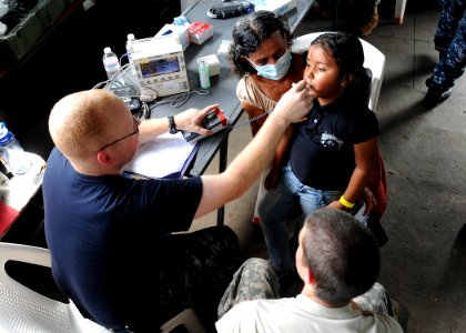 US Navy 110630-F-ET173-095 Hospital Corpsman 3rd Class Shannon Sensenig checks a patient's temperature at the Los Angeles surgical screening site photo