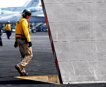 US Navy 110630-N-GL340-001 Lt. Jerrod Washburn, a flight deck shooter, checks a jet blast deflector before flight operations aboard the aircraft ca