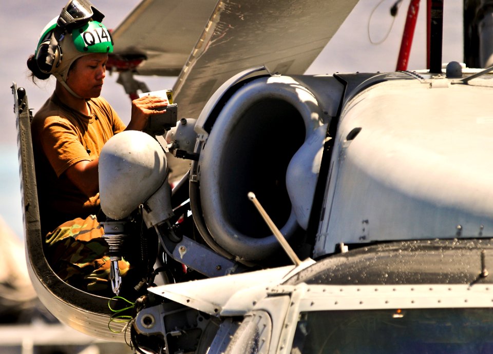 US Navy 110628-N-KB563-009 Aviation Structural Mechanic 2nd Class Bonnafaye Cabajar installs a rescue hoist on an MH-60S Sea Hawk helicopter aboard