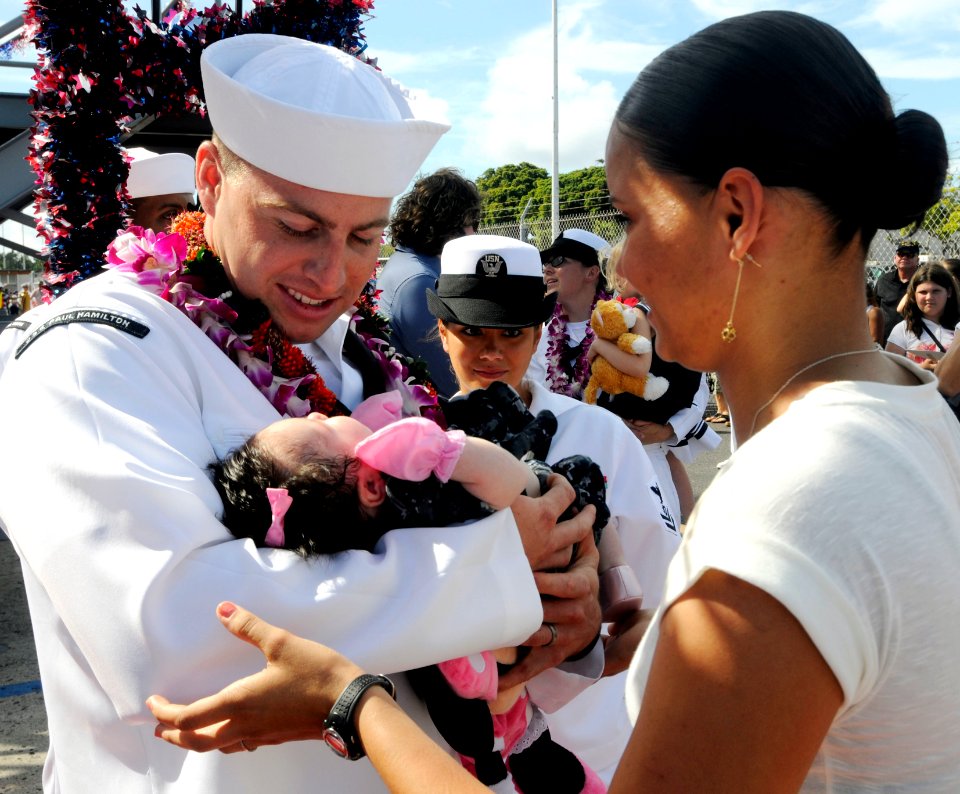 US Navy 110629-N-WX059-212 Damage Controlman 2nd Class Alex Joppe holds his baby for the first time after returning from a seven-month deployment