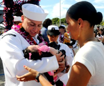 US Navy 110629-N-WX059-212 Damage Controlman 2nd Class Alex Joppe holds his baby for the first time after returning from a seven-month deployment