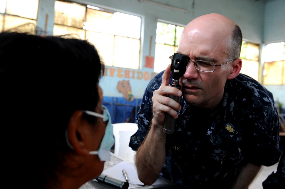 US Navy 110630-F-ET173-122 Capt. William Sray checks a patient's eyes during an exam at the Los Angeles surgical screening site
