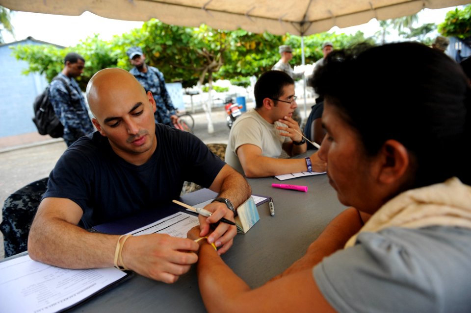 US Navy 110630-F-ET173-030 Hospital Corpsman 1st Class Mark Marin marks a patient's wristband with services that will be provided at the Los Angele