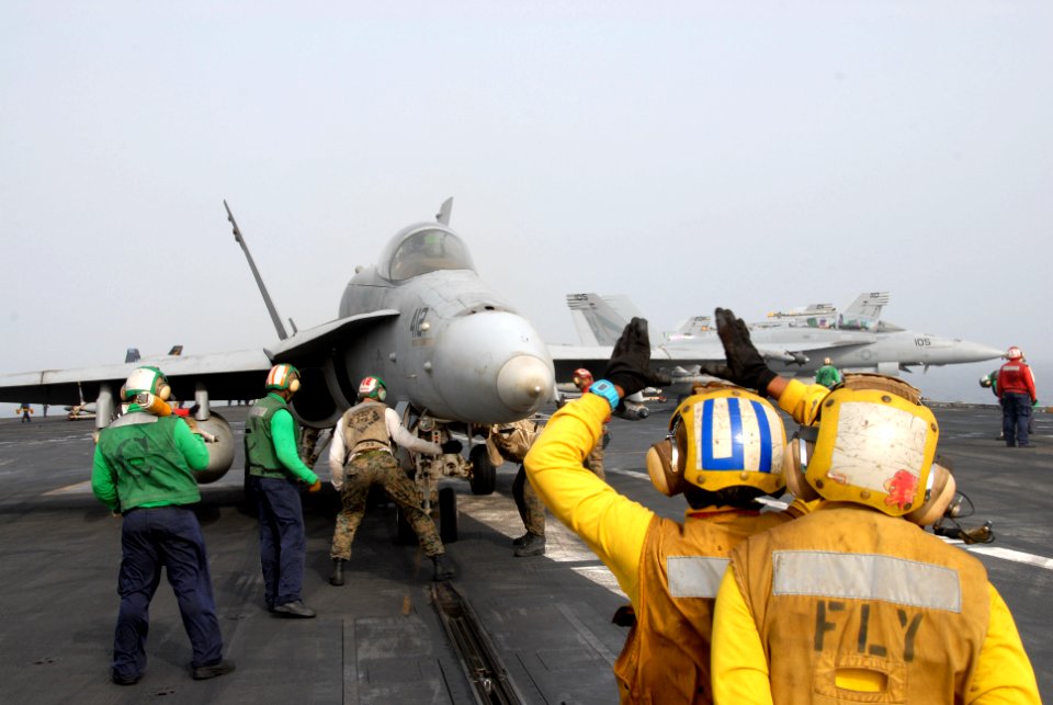 US Navy 110703-N-KF029-081 Aviation Boatswain's Mate (Handling) 3rd Class Olivia Dimas, from Arlington, Texas, instructs another Sailor how to dire