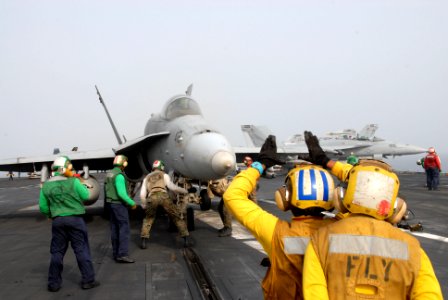 US Navy 110703-N-KF029-081 Aviation Boatswain's Mate (Handling) 3rd Class Olivia Dimas, from Arlington, Texas, instructs another Sailor how to dire
