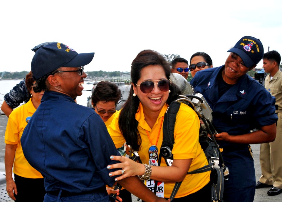 US Navy 110630-N-NJ145-013 Damage Controlman Fireman Apprentice Sharaine Robinson supports Becky Labit as dons a self contained breathing apparatus