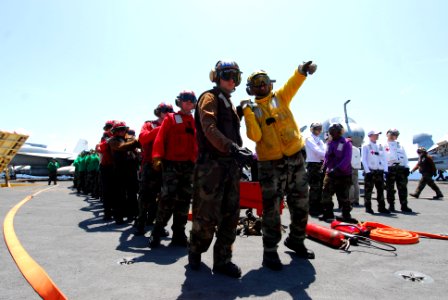 US Navy 110702-N-AW206-016 Aviation Boatswain's Mate (Handling) 2nd Class Andre Rowe instructs hose team members during a barricade drill aboard US