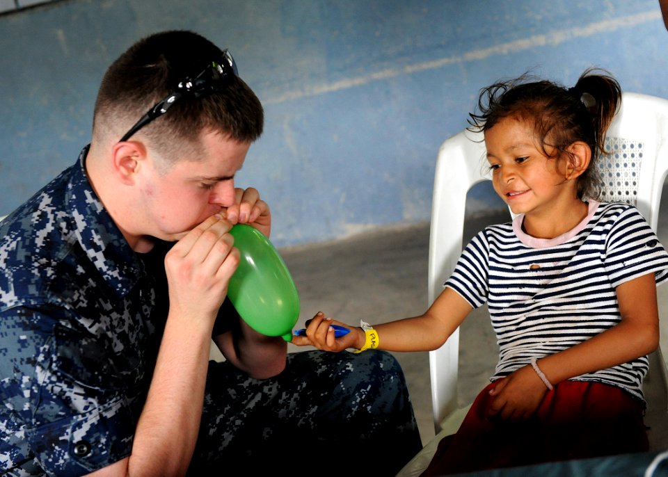 US Navy 110630-F-ET173-201 Hospitalman James Allen blows up a balloon for a patient at the Los Angeles surgical screening site