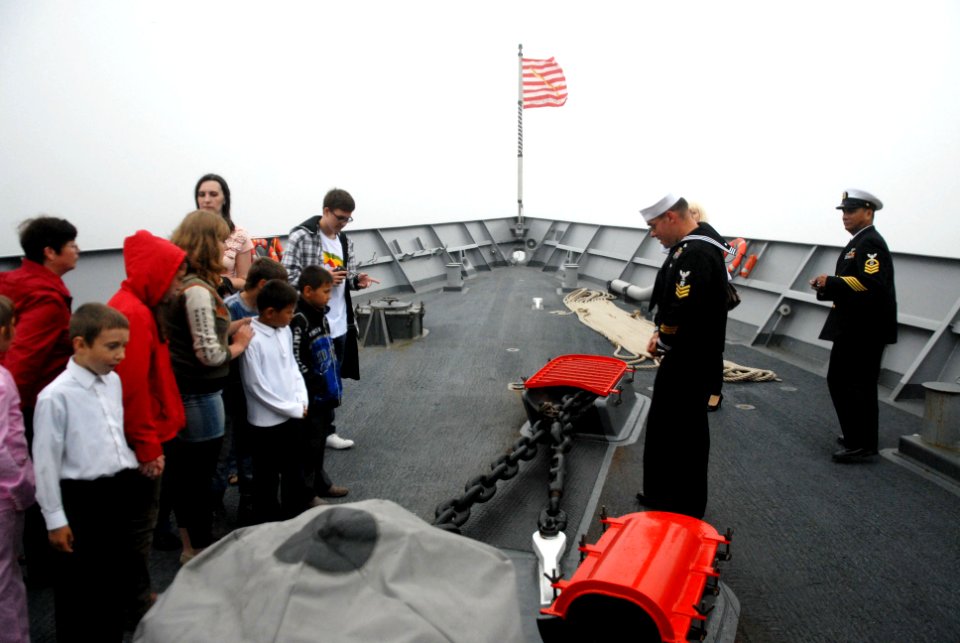 US Navy 110703-N-MU720-202 Boatswain's Mate 1st Class Samuel Siemers talks about the capabilities of USS Ford (FFG 54) to children from the Parus N