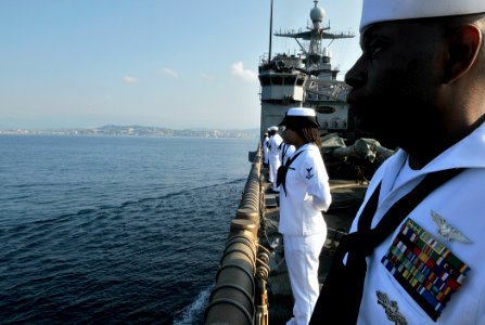 US Navy 110703-N-AG285-032 Personnel Specialist 1st Class Darryl Thomas mans the rails aboard USS Whidbey Island (LSD 41), as the ship anchors off