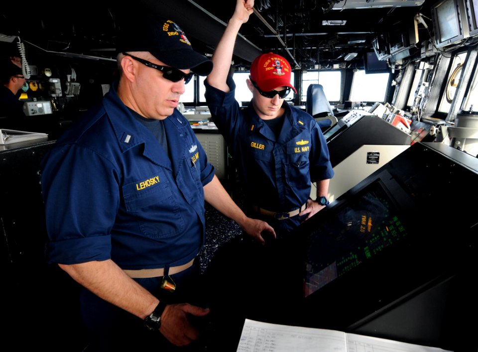 US Navy 110705-N-TB177-043 Ensign Daniel Giller, right, observes as Lt. j.g. Joseph Lehosky uses an SPS-73 navigational radar to navigate the guide