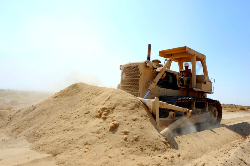 US Navy 110705-N-WL435-178 Master Chief Equipment Operator Charles Boris pushes sand with a bulldozer to reinforce an existing berm at a joint forc