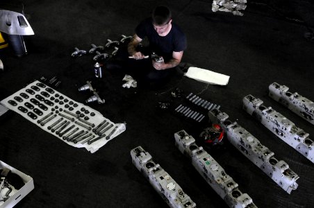 US Navy 110701-N-YC505-017 Aviation Ordnanceman 1st Class Chuck Block cleans aircraft parts in the hangar bay aboard the aircraft carrier USS Georg