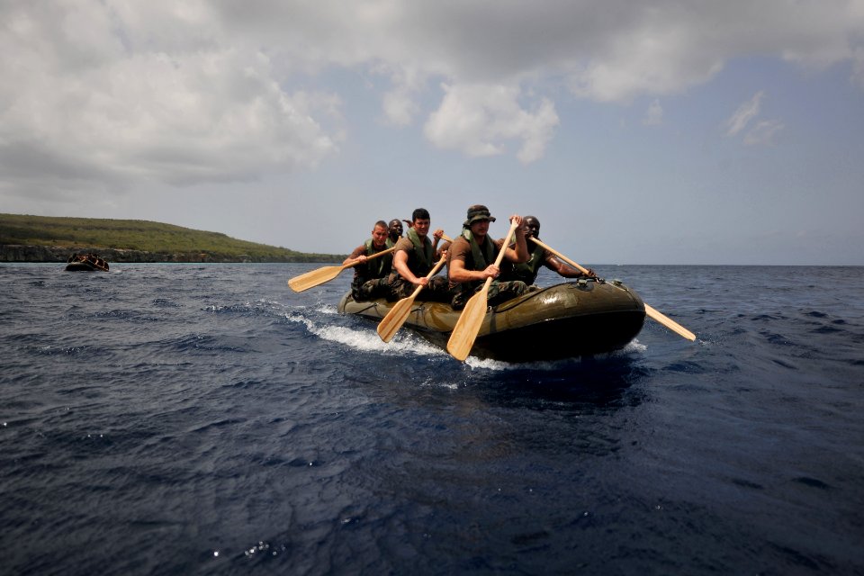 US Navy 110705-N-YO394-124 Sailors and Royal Netherlands marines paddle an inflatable boat during a six-kilometer amphibious march along the island