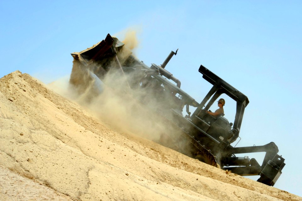US Navy 110705-N-WL435-062 Equipment Operator Constructionman Jacob Osburn uses a bulldozer to push sand to reinforce a berm at a joint forces weap