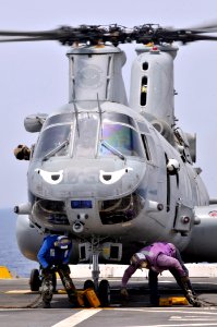 US Navy 110706-N-GW695-079 Airmen remove chocks and tie-down chains from a CH-46 Sea Knight helicopter