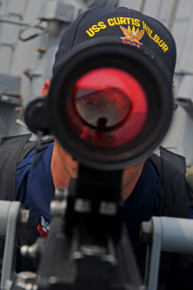 US Navy 110706-N-IO627-119 Gunner's Mate 1st Class Robert Jackson aims an MK 38 Mod 2 25 mm machine gun aboard USS Curtis Wilbur (DDG 54)