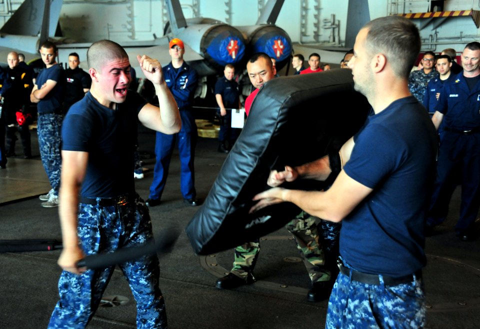 US Navy 110707-N-OP638-030 lectrician's Mate Fireman Kaleb E. Cannon practices using a baton during a security qualification exercise in the hangar
