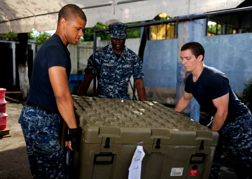 US Navy 110707-N-RM525-056 Hospitalmen Melvin Neal, left, Augustus Lartey and David Anton carry a crate of medical supplies to a pallet during a si