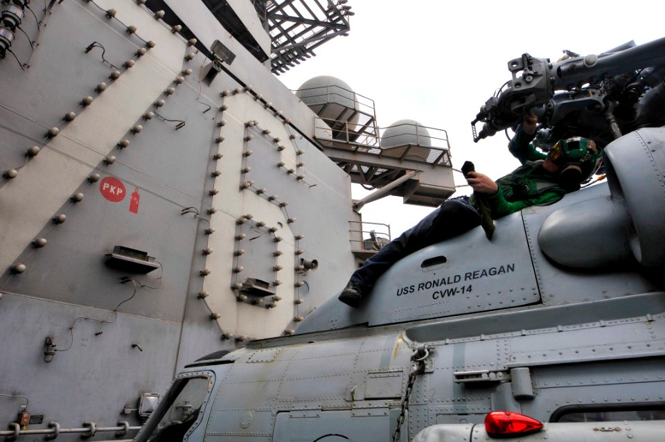 US Navy 110710-N-EE987-389 Aviation Machinist's Mate 2nd Class Brandon Rucker, from San Diego, performs daily maintenance on an SH-60F Sea Hawk hel