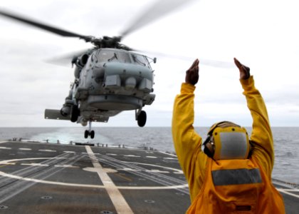 US Navy 110711-N-ZI300-135 A landing signal enlisted signals to the pilots of an SH-60B Sea Hawk helicopter taking off from the guided-missile frig