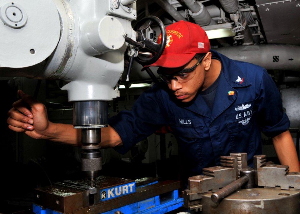 US Navy 110708-N-CH661-003 Machinery Repairman 3rd Class Joshua J. Mills fabricates a door hinge aboard the aircraft carrier USS Enterprise (CVN 65