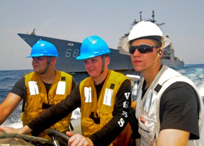 US Navy 110709-N-YM590-051 Sailors guide a rigid-hull inflatable boat past the guided-missile cruiser USS Anzio (CG 68)