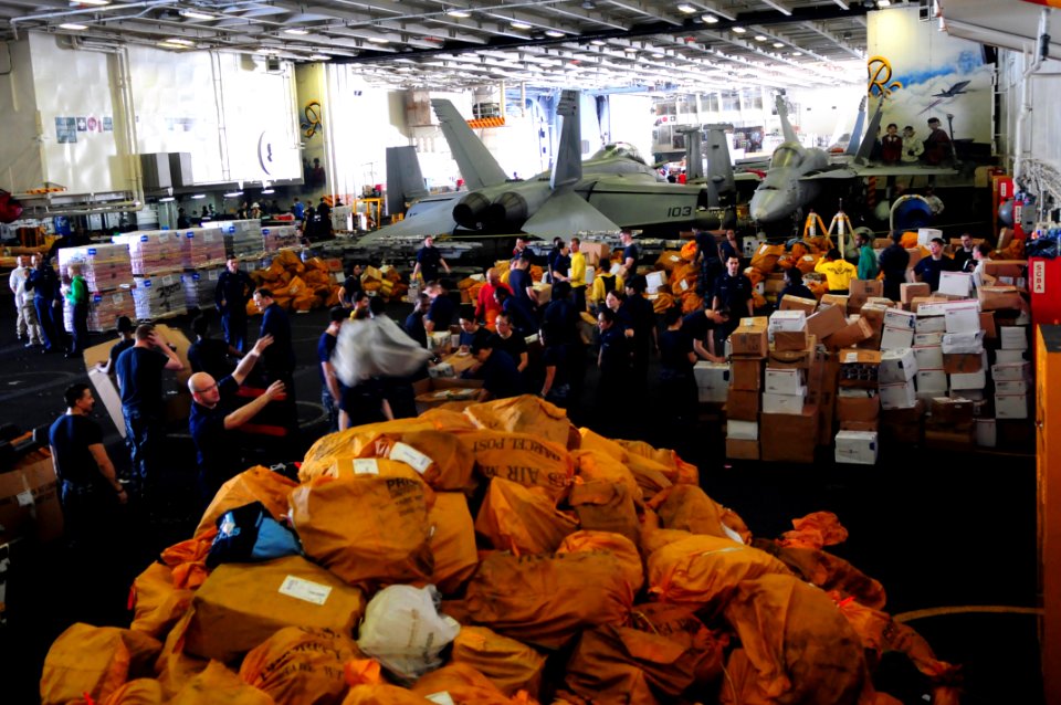 US Navy 110707-N-UO379-481 Sailors and Marines organize mail packages and letters in the hangar bay of the aircraft carrier USS Ronald Reagan (CVN