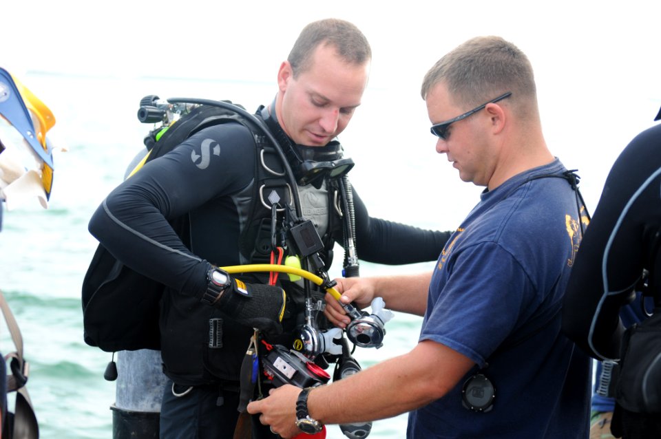 US Navy 110707-N-MN220-074 Navy Diver 2nd Class Nick Barna, left, a basic diver assigned to Navy Dive Locker Guantanamo, receives a pre-dive equipm