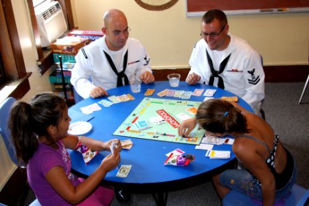 US Navy 110713-N-NT881-124 Personnel Specialist 2nd Class James Vail, left, and Boatswain's Mate 2nd Class Nathaniel Eaton play board games with ch