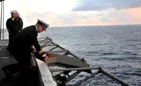 US Navy 110710-N-OP638-036 Cmdr. Todd Mullis pours ashes over the side of the ship during a burial at sea ceremony aboard USS Enterprise (CVN 65) photo