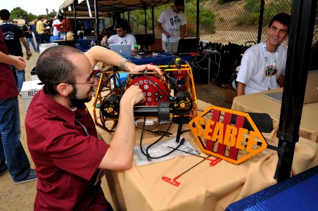 US Navy 110713-N-UN340-029 Noah Olsman prepares his team's autonomous underwater vehicle, SeaBee III, for a practice run