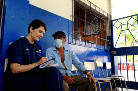 US Navy 110715-F-ET173-034 Coast Guard Cmdr. Camille Hawkins, from Ft. Lauderdale, Fla., records a patient's medical history at a surgical screenin
