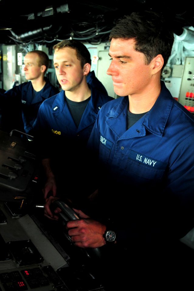 US Navy 110711-N-ZS026-476 Helmsman Seaman Zachary Erick, right, steers the amphibious assault ship USS Boxer (LHD 4) under the direction of helm s