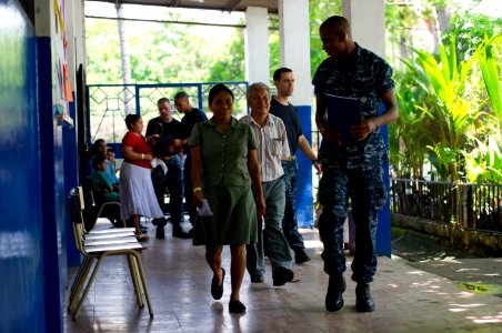 US Navy 110714-N-RM525-112 Hospitalman Erique Lynn, from Ashford, Ala., escorts Salvadorans to the next medical station during a Continuing Promise