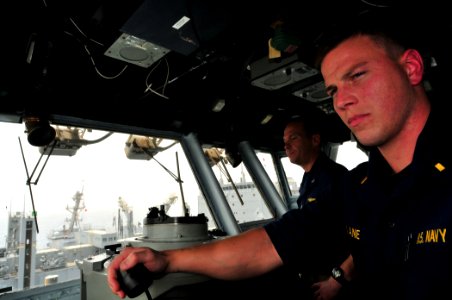US Navy 110711-N-ZS026-471 Capt. Frank Michael and Ensign Alex Lane oversee and direct course and speed changes from the ship's bridge